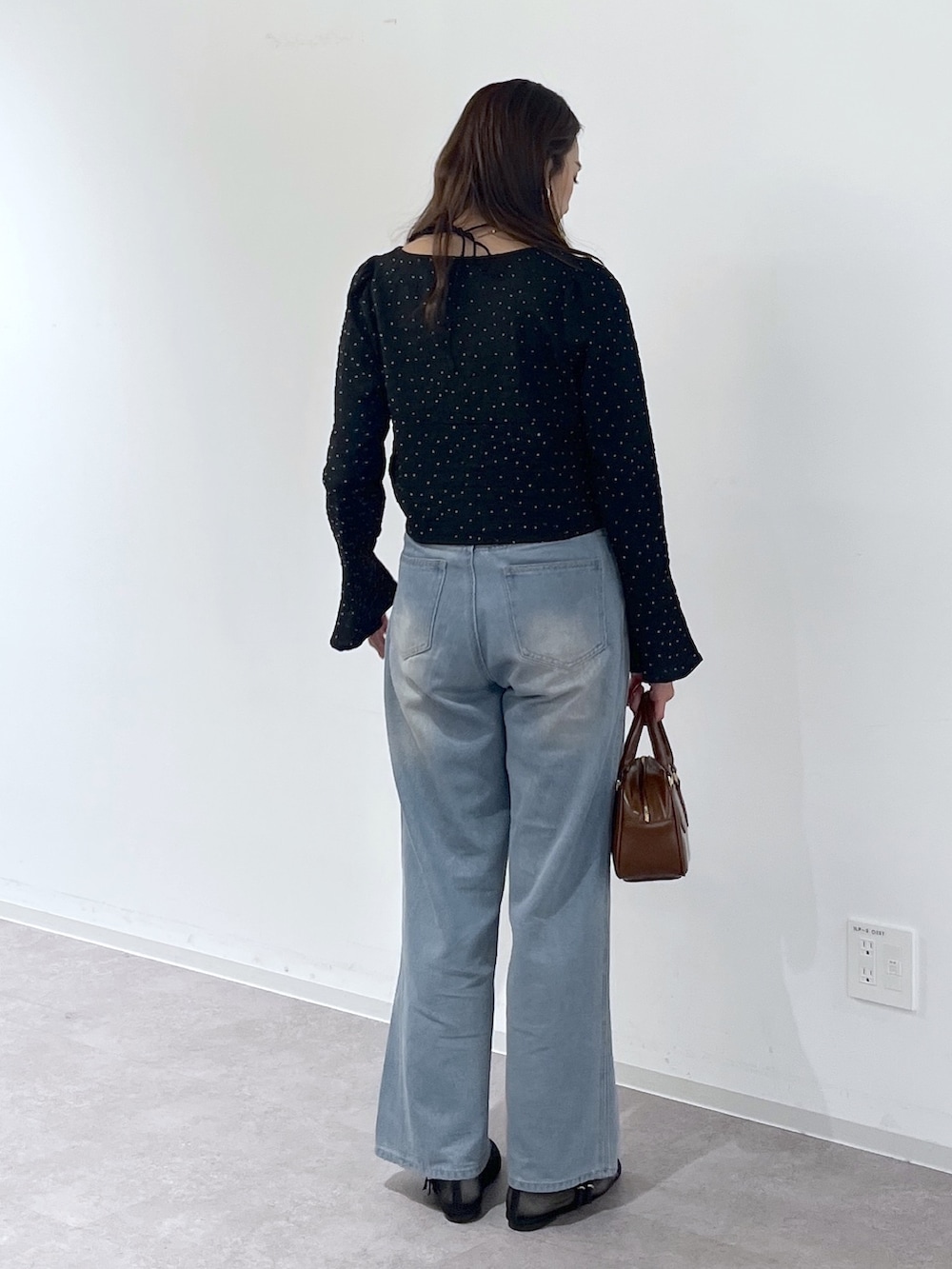 ブラック系のシャツ/ブラウス、ブラウン系のハンドバッグ、ブラック系のパンプスを着用したレディースの冬コーディネートの5枚目の写真