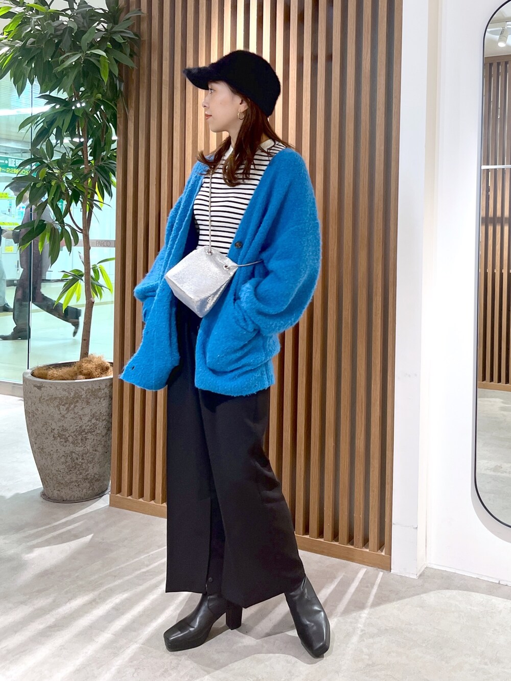 ブルー系のカーディガン/ボレロ、ホワイト系のニット/セーター、ブラック系のスラックスを着用したレディースの秋コーディネートの3枚目の写真