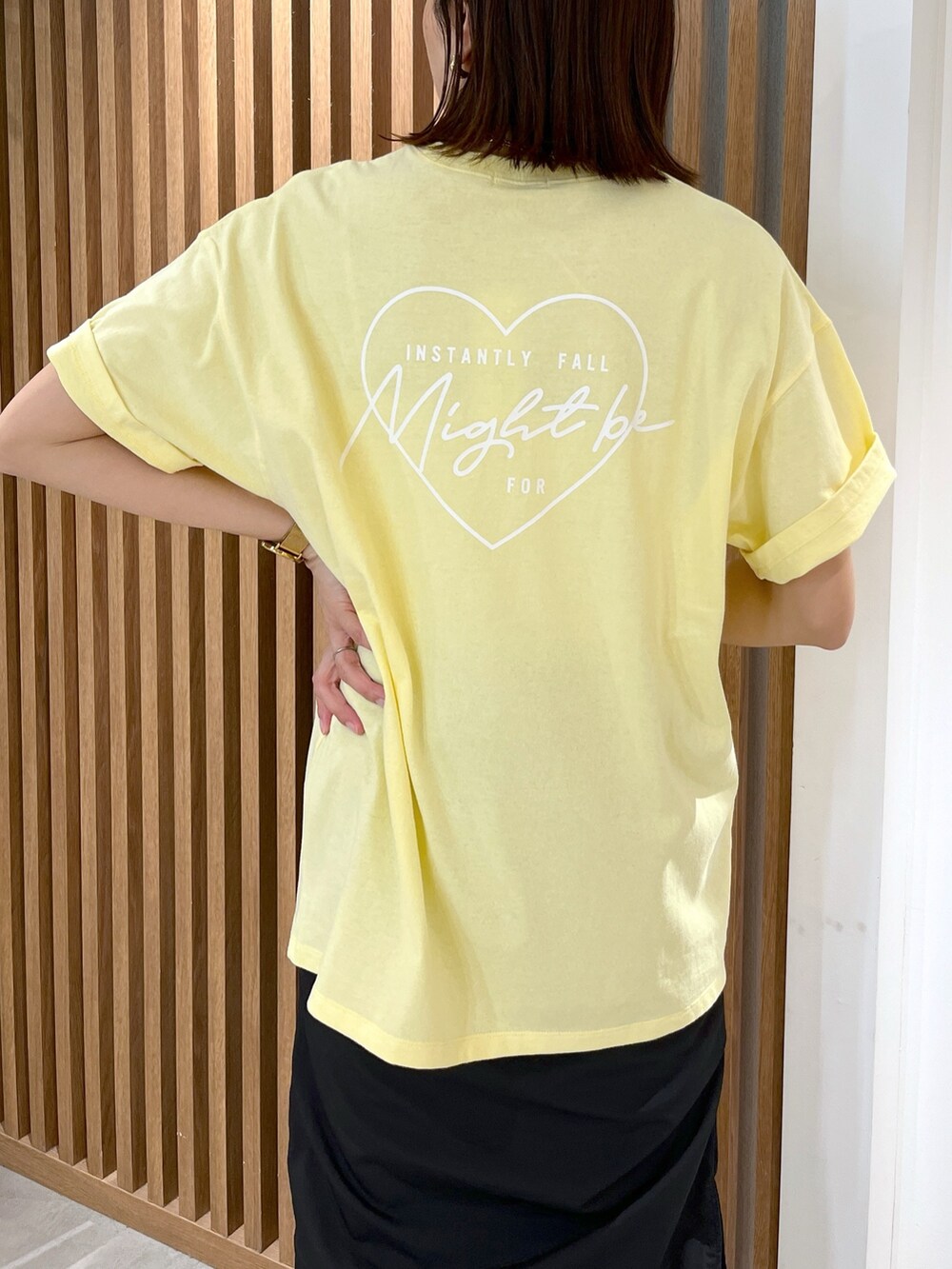 イエロー系のTシャツ/カットソー、ホワイト系のショルダーバッグ、ブラック系のスカートを着用したレディースの春コーディネートの7枚目の写真