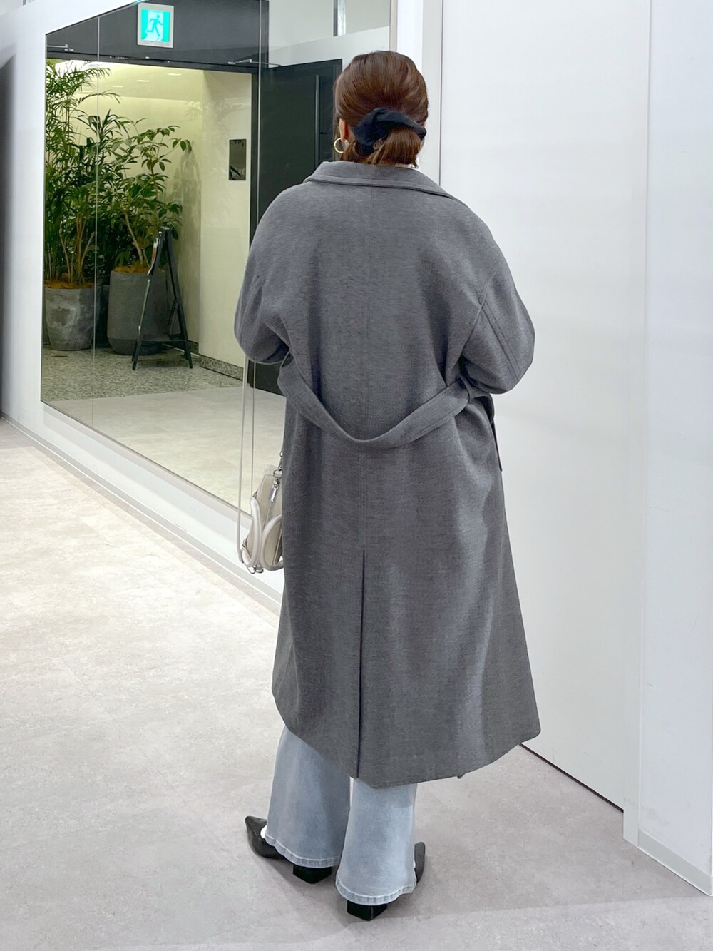 ホワイト系のTシャツ/カットソー、グレー系のステンカラーコート、ブルー系のニット/セーターを着用したレディースの秋コーディネートの9枚目の写真