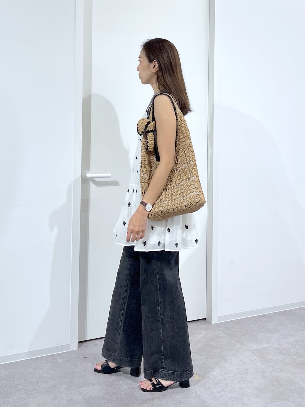 ブラック系のTシャツ/カットソー、ホワイト系のワンピース、ブラック系のデニムパンツを着用したレディースの夏コーディネートの5枚目の写真