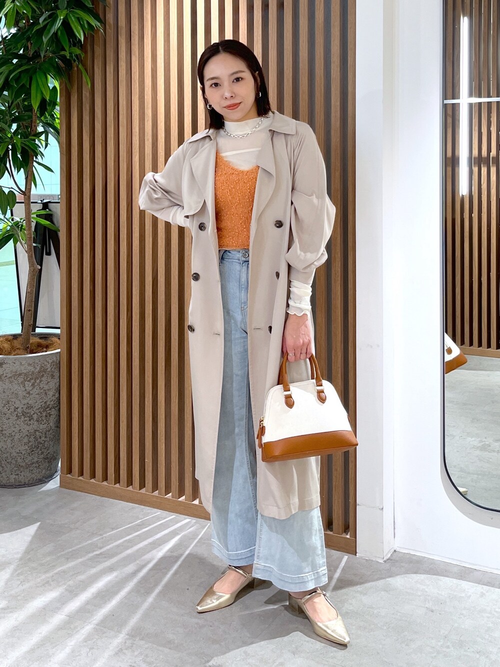 ブラウン系のショルダーバッグ、ホワイト系のTシャツ/カットソー、オレンジ系のベストを着用したレディースの春コーディネートの2枚目の写真