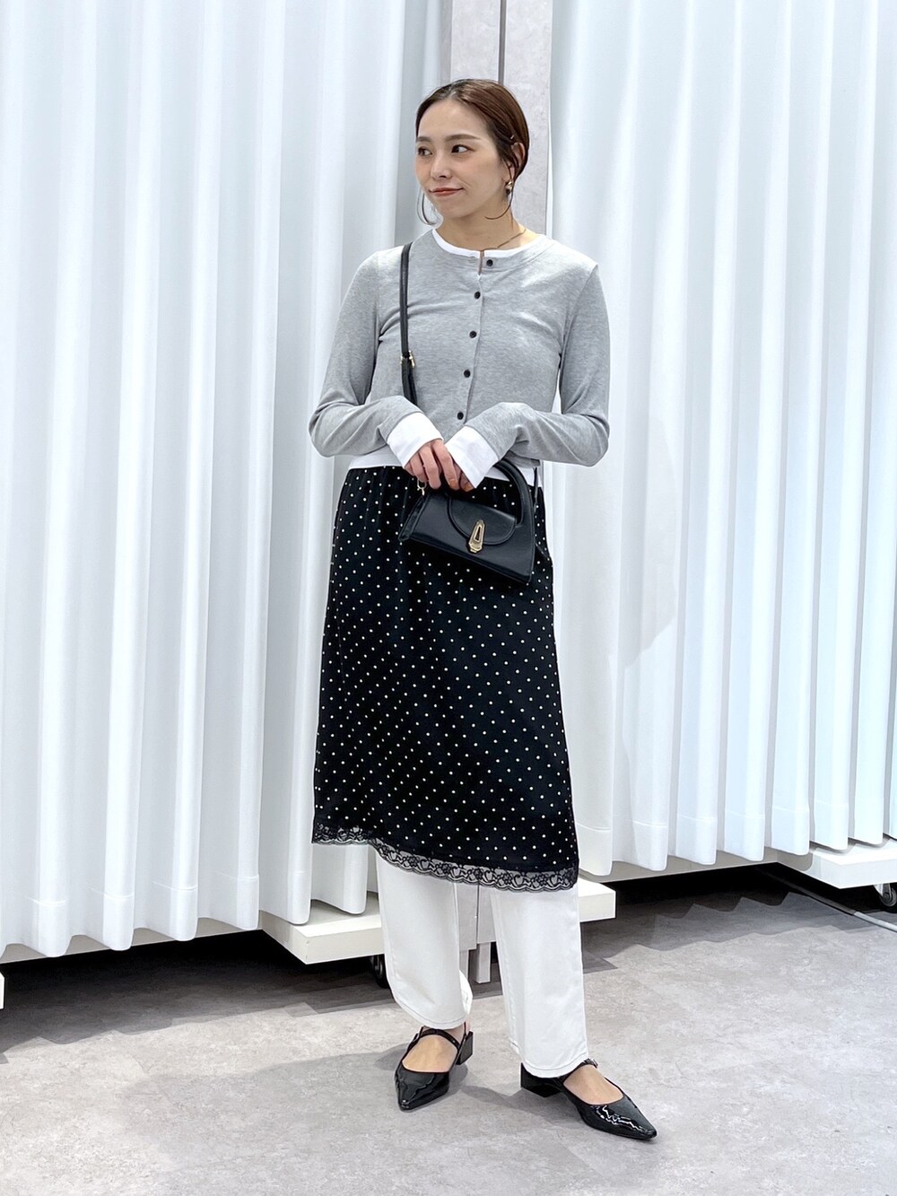 ブラック系のスカート、グレー系のTシャツ/カットソー、ホワイト系のデニムパンツを着用したレディースの春コーディネートの9枚目の写真