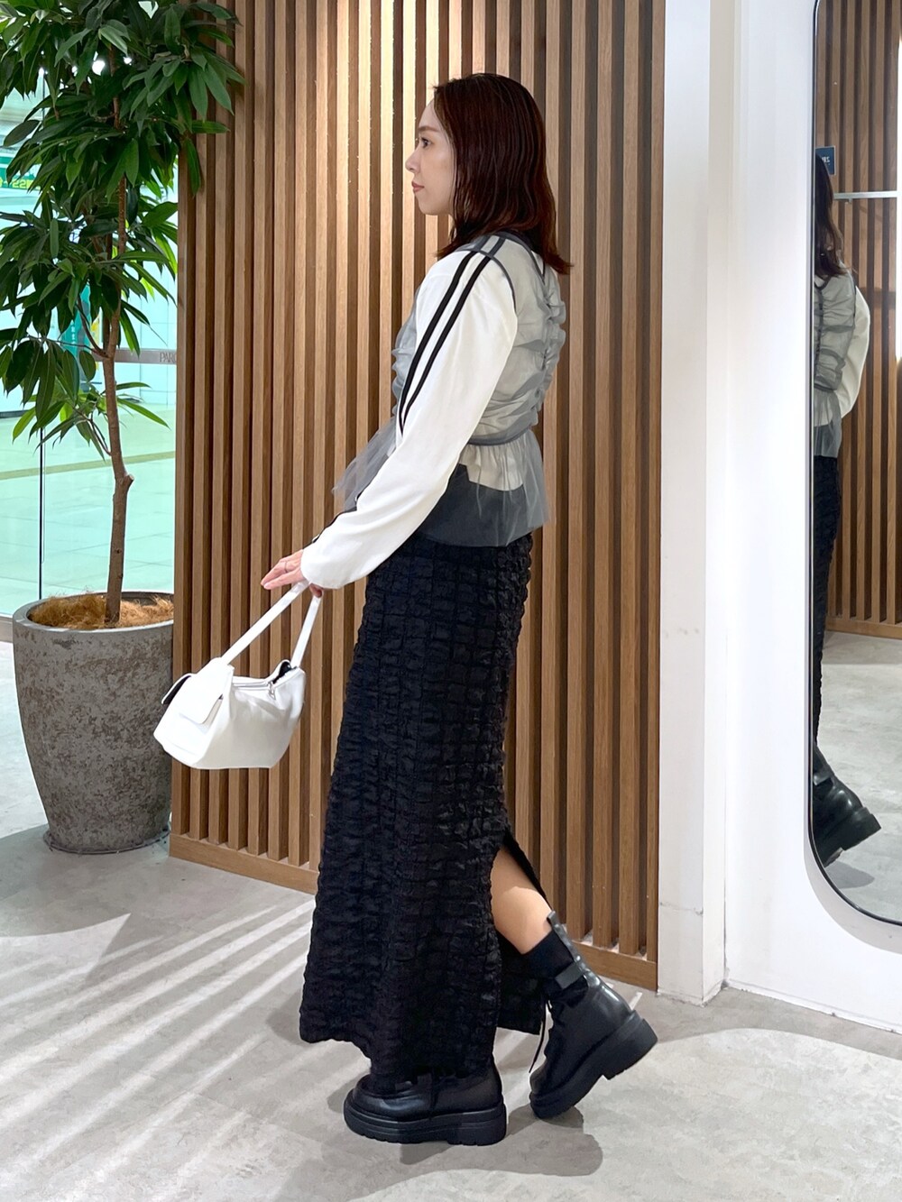 ホワイト系のTシャツ/カットソー、グレー系のシャツ/ブラウス、ブラック系のスカートを着用したレディースの秋コーディネートの4枚目の写真