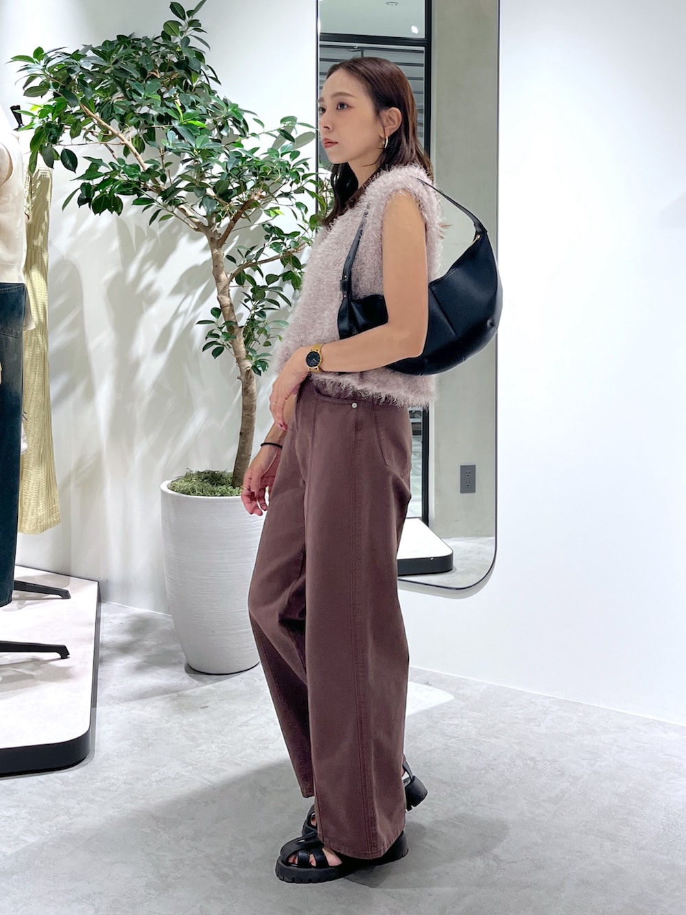 ベージュ系のニット/セーター、ブラック系のハンドバッグ、ブラウン系のデニムパンツを着用したレディースの夏コーディネートの7枚目の写真