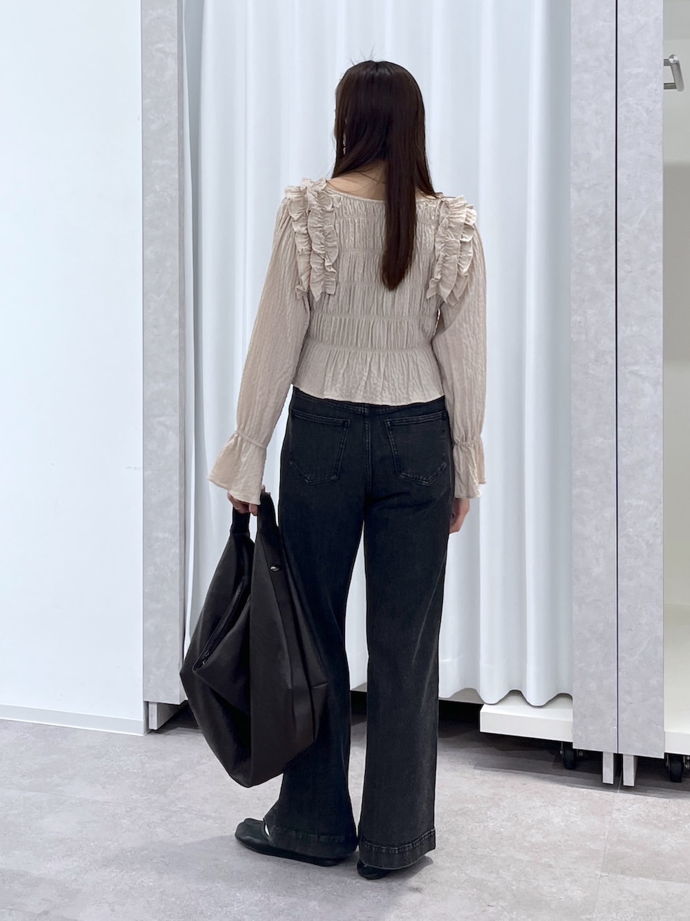 ベージュ系のシャツ/ブラウス、ブラウン系のトートバッグ、ブラック系のデニムパンツを着用したレディースの冬コーディネートの5枚目の写真