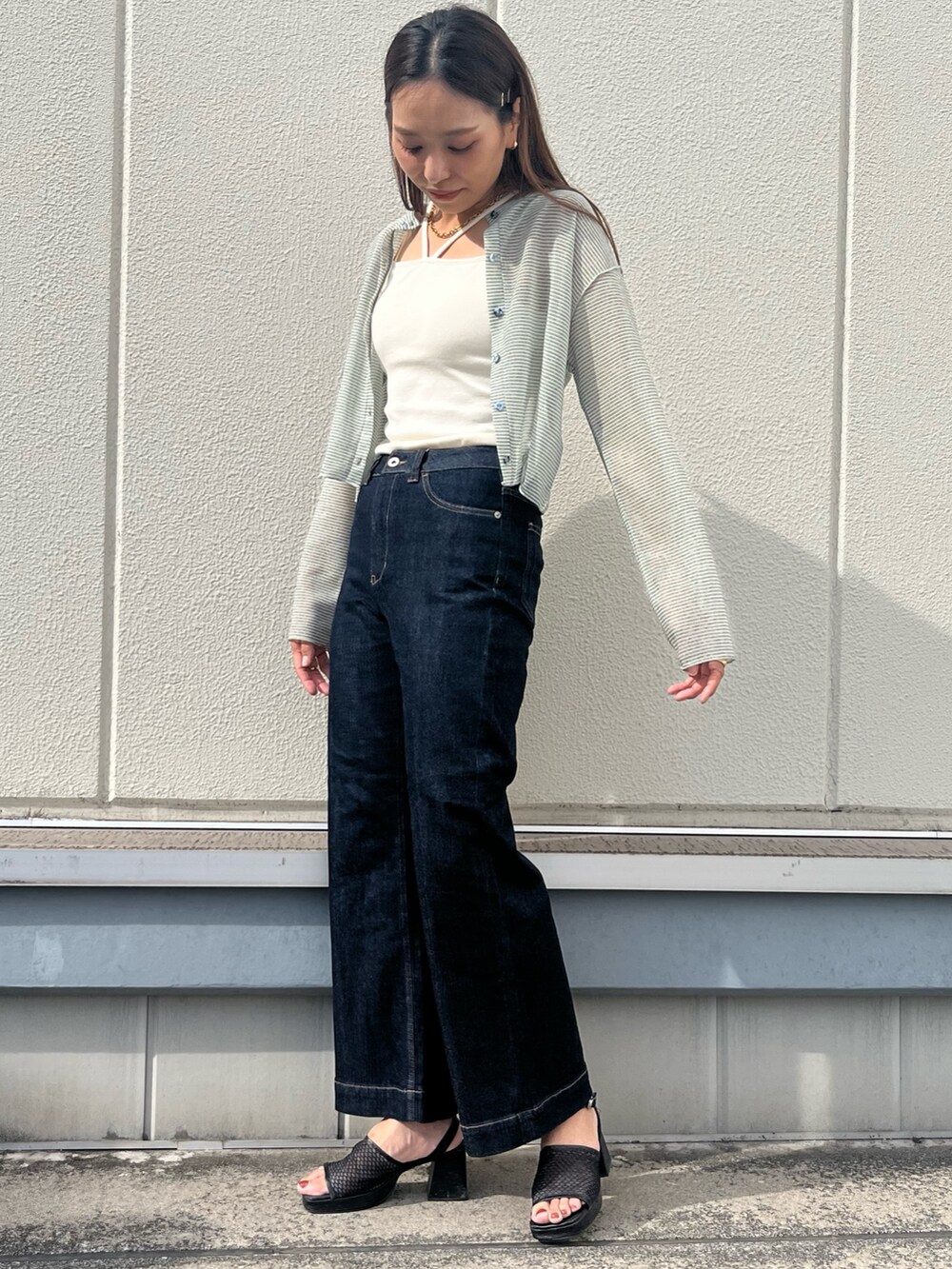 ブルー系のデニムパンツ、ホワイト系のキャミソール、グリーン系のカーディガン/ボレロを着用したレディースの夏コーディネートの2枚目の写真