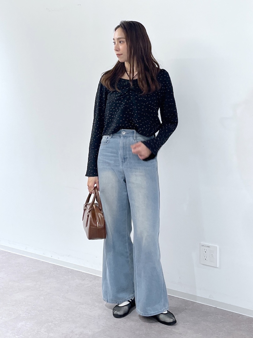 ブラック系のシャツ/ブラウス、ブラウン系のハンドバッグ、ブラック系のパンプスを着用したレディースの冬コーディネートの7枚目の写真