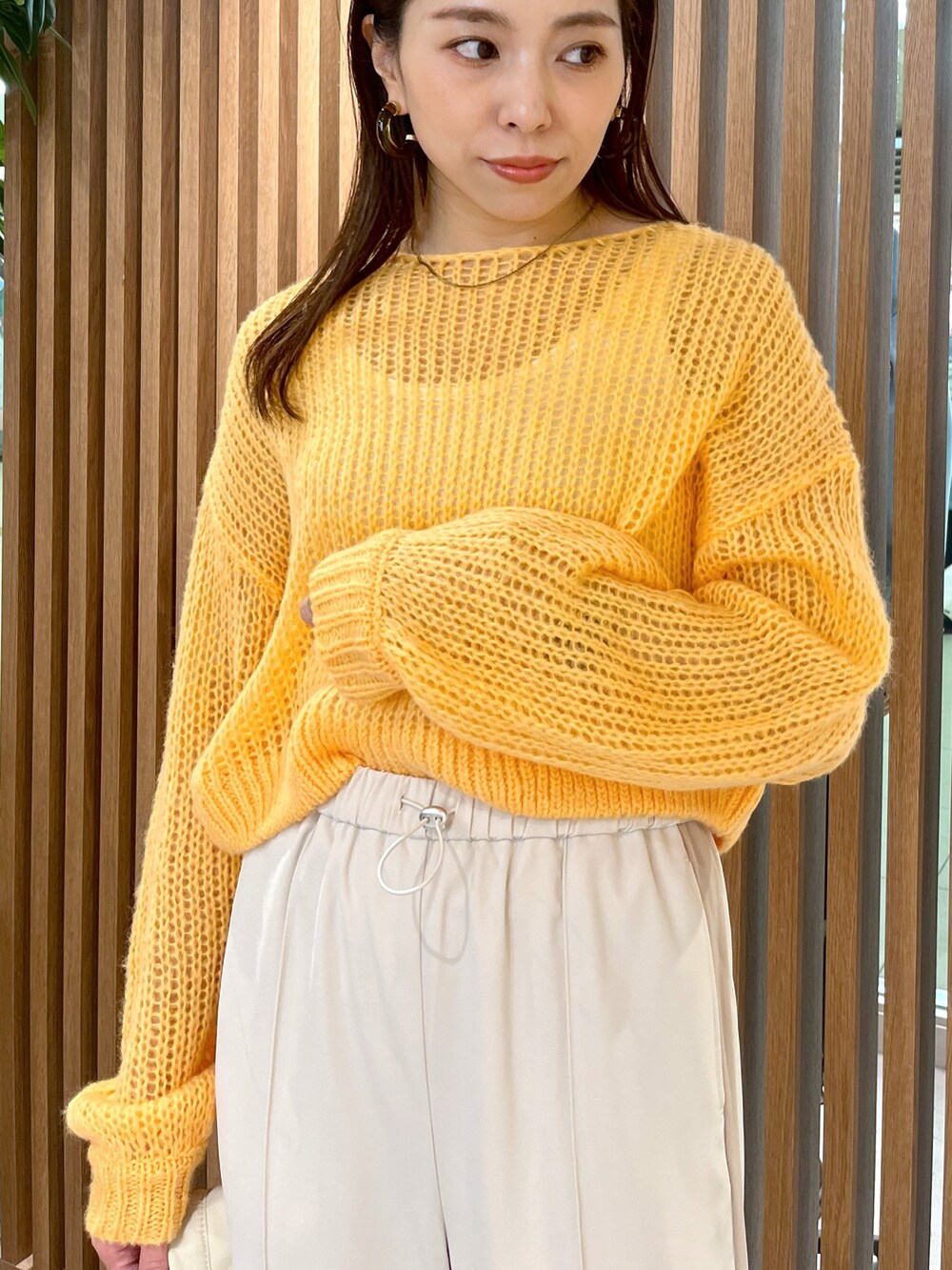 ホワイト系のショルダーバッグ、オレンジ系のニット/セーター、ホワイト系のその他パンツを着用したレディースの冬コーディネートの8枚目の写真