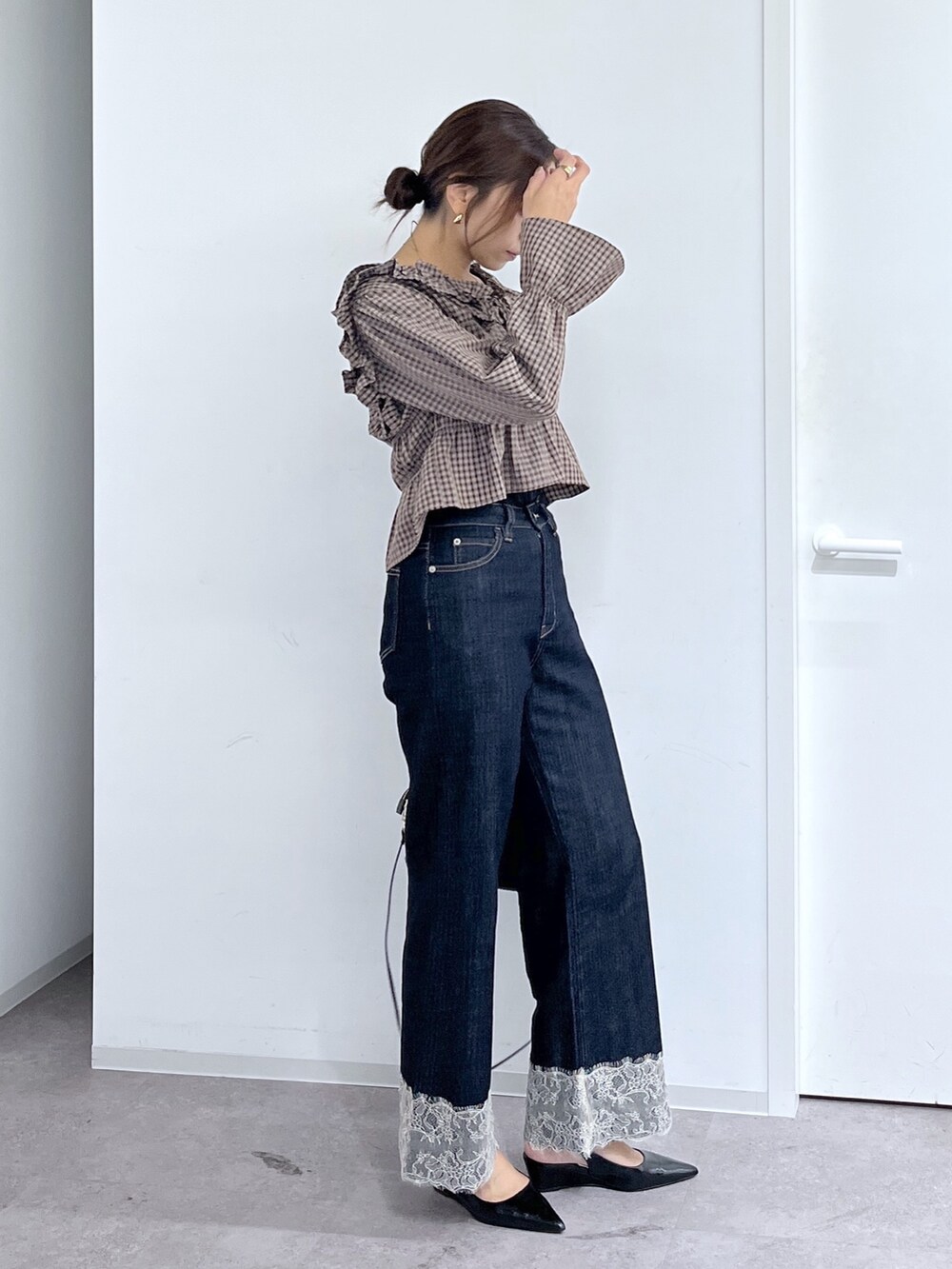 ブルー系のデニムパンツ、ブラック系のハンドバッグ、ブラウン系のシャツ/ブラウスを着用したレディースの秋コーディネートの8枚目の写真