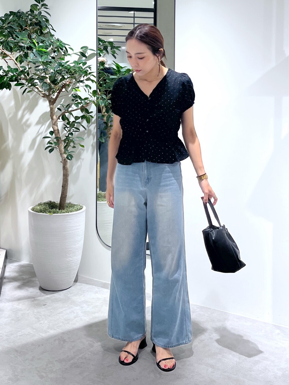 ブラック系のショルダーバッグ、ブルー系のデニムパンツ、ブラック系のシャツ/ブラウスを着用したレディースの夏コーディネートの3枚目の写真