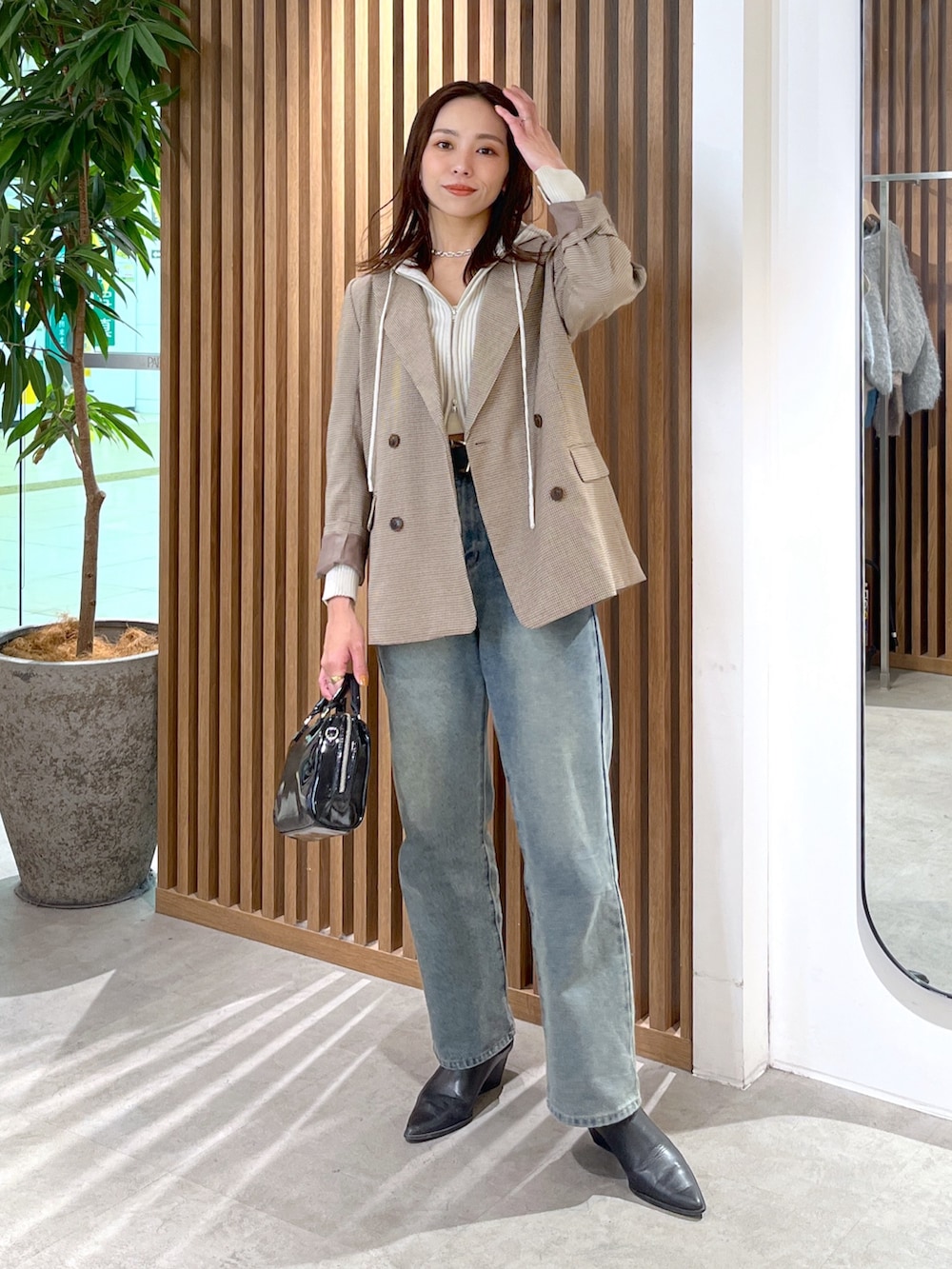 ホワイト系のニット/セーター、ベージュ系のテーラードジャケット、ブルー系のデニムパンツを着用したレディースの冬コーディネートの4枚目の写真