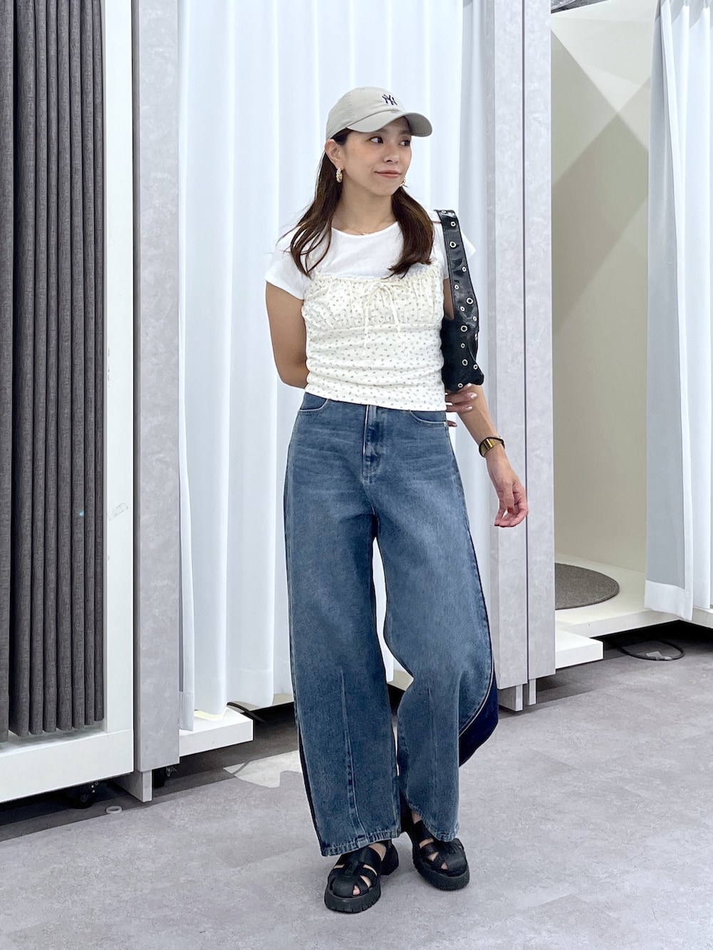 ホワイト系のTシャツ/カットソー、ブルー系のデニムパンツ、ブラック系のショルダーバッグを着用したレディースの夏コーディネートの2枚目の写真