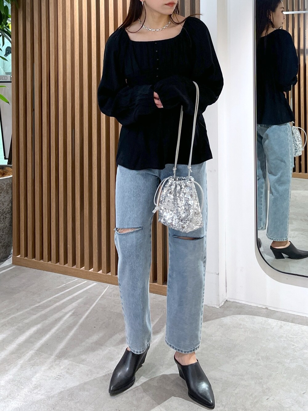 ブラック系のシャツ/ブラウス、ブルー系のデニムパンツ、シルバー系のハンドバッグを着用したレディースの冬コーディネートの3枚目の写真