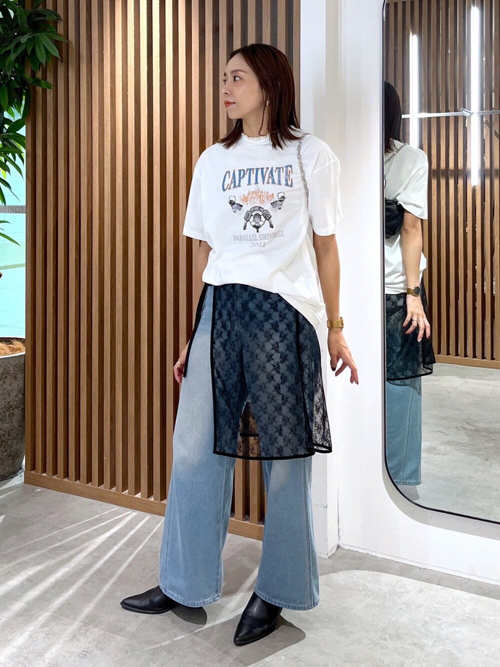 ホワイト系のTシャツ/カットソー、ブラック系のハンドバッグ、ブラック系のスカートを着用したレディースの秋コーディネートの3枚目の写真