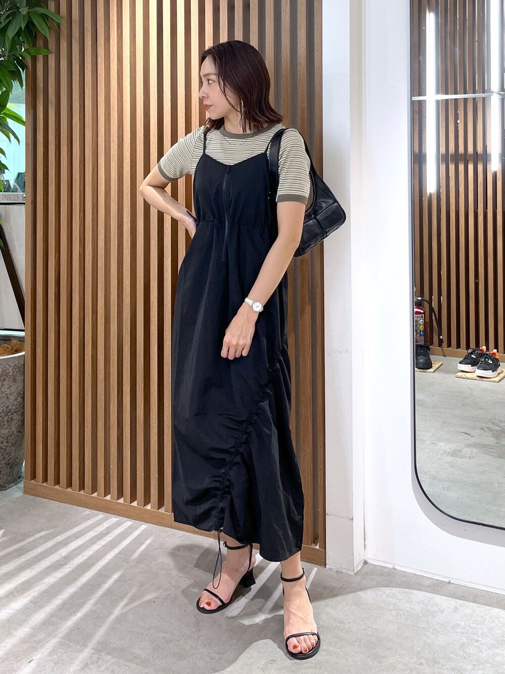 グリーン系のTシャツ/カットソー、ブラック系のショルダーバッグ、ブラック系のサンダルを着用したレディースの春コーディネートの7枚目の写真