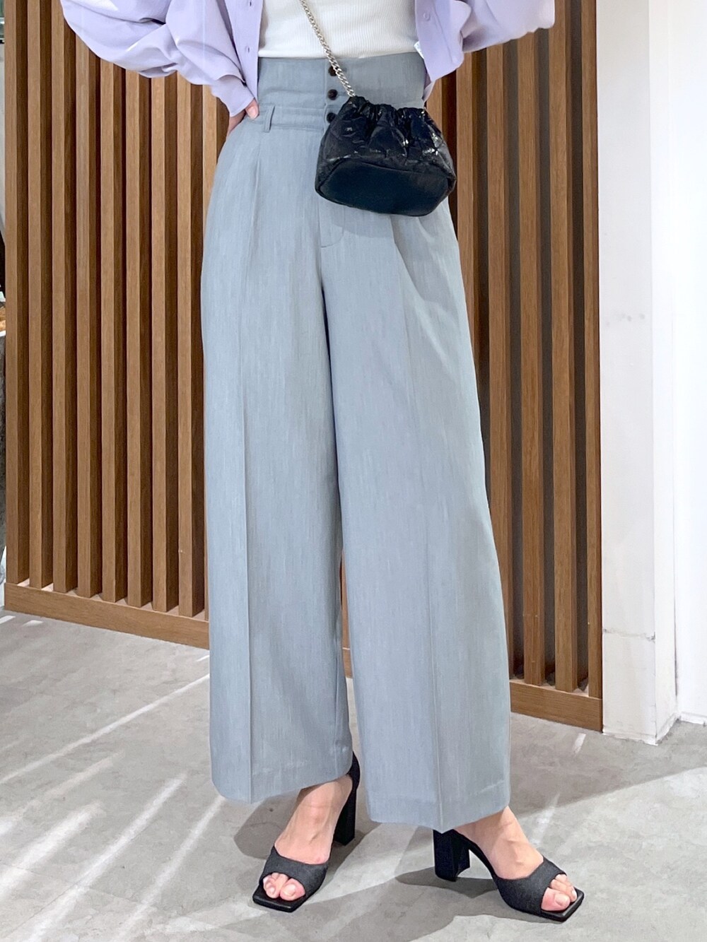 ブラック系のサンダル、グレー系のスラックス、ブラック系のショルダーバッグを着用したレディースの春コーディネートの7枚目の写真