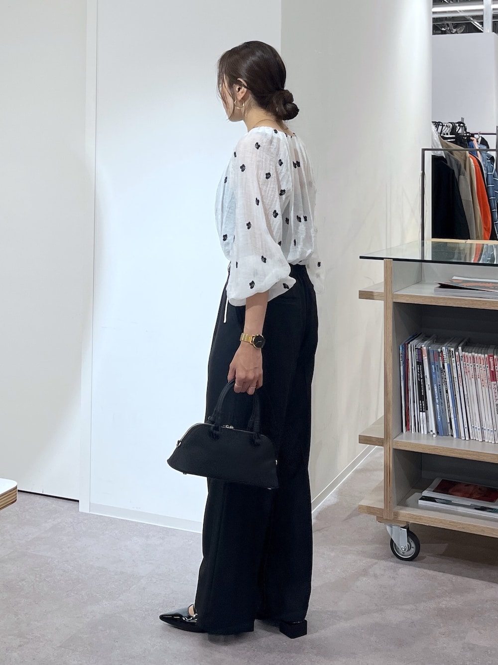 ブラック系のボストンバッグ、ブラック系のスラックス、ブラック系のパンプスを着用したレディースの夏コーディネートの5枚目の写真