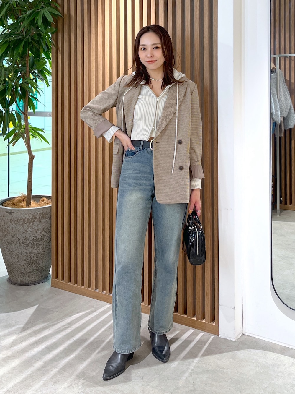 ホワイト系のニット/セーター、ベージュ系のテーラードジャケット、ブルー系のデニムパンツを着用したレディースの冬コーディネートの3枚目の写真