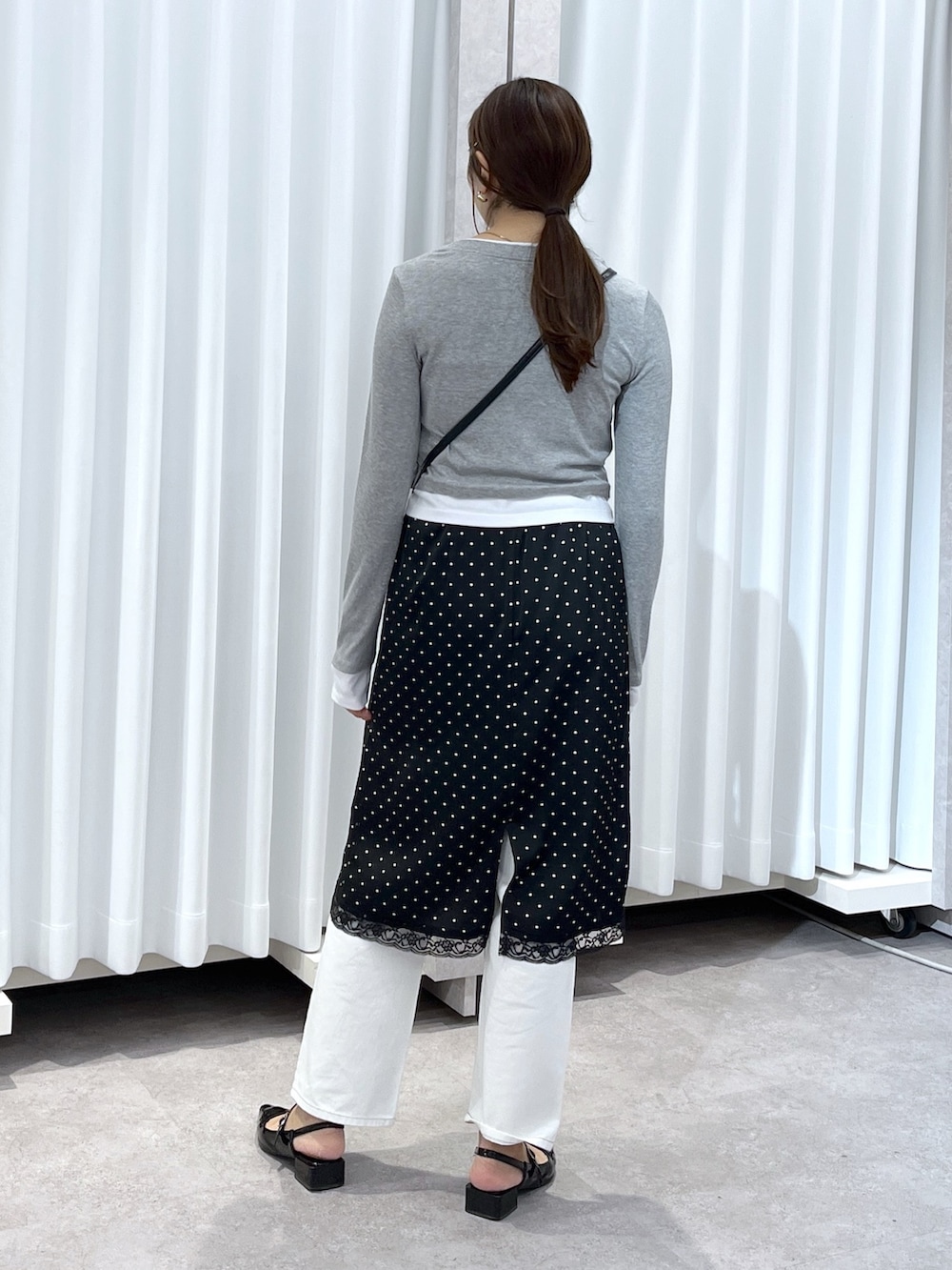 ブラック系のスカート、グレー系のTシャツ/カットソー、ホワイト系のデニムパンツを着用したレディースの春コーディネートの6枚目の写真