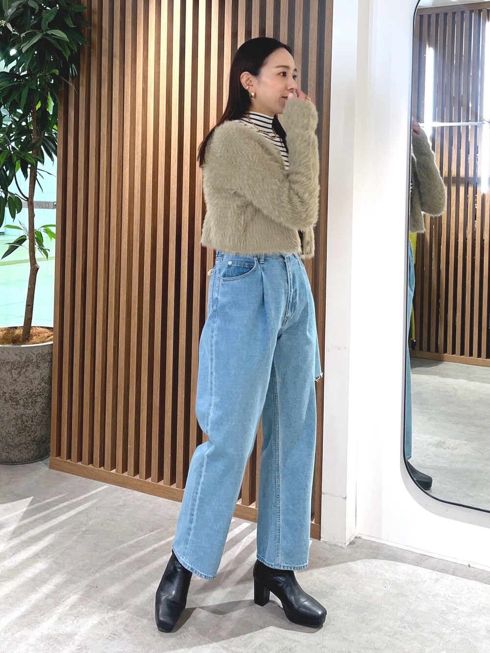 ベージュ系のカーディガン/ボレロ、ブルー系のデニムパンツ、ホワイト系のニット/セーターを着用したレディースの冬コーディネートの5枚目の写真