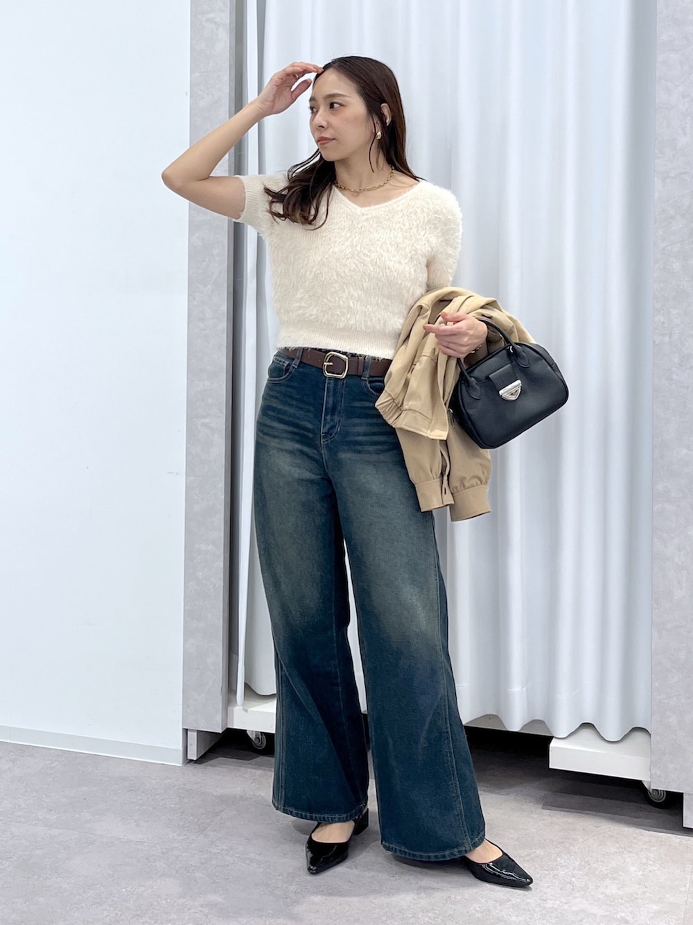 ベージュ系のブルゾン、ホワイト系のニット/セーター、ブルー系のデニムパンツを着用したレディースの春コーディネートの6枚目の写真