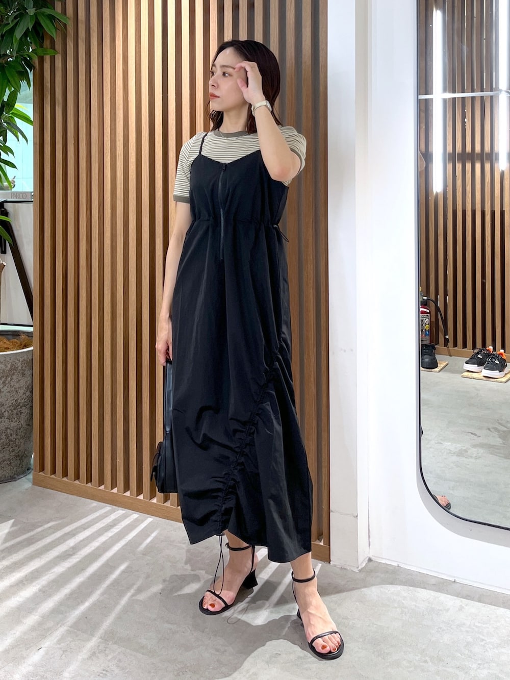 グリーン系のTシャツ/カットソー、ブラック系のショルダーバッグ、ブラック系のサンダルを着用したレディースの春コーディネートの2枚目の写真