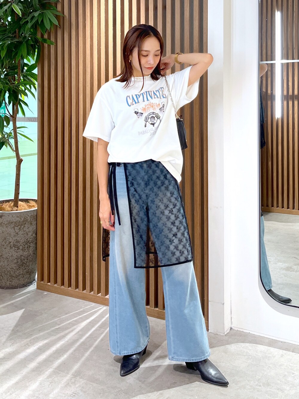 ホワイト系のTシャツ/カットソー、ブラック系のハンドバッグ、ブラック系のスカートを着用したレディースの秋コーディネートの8枚目の写真