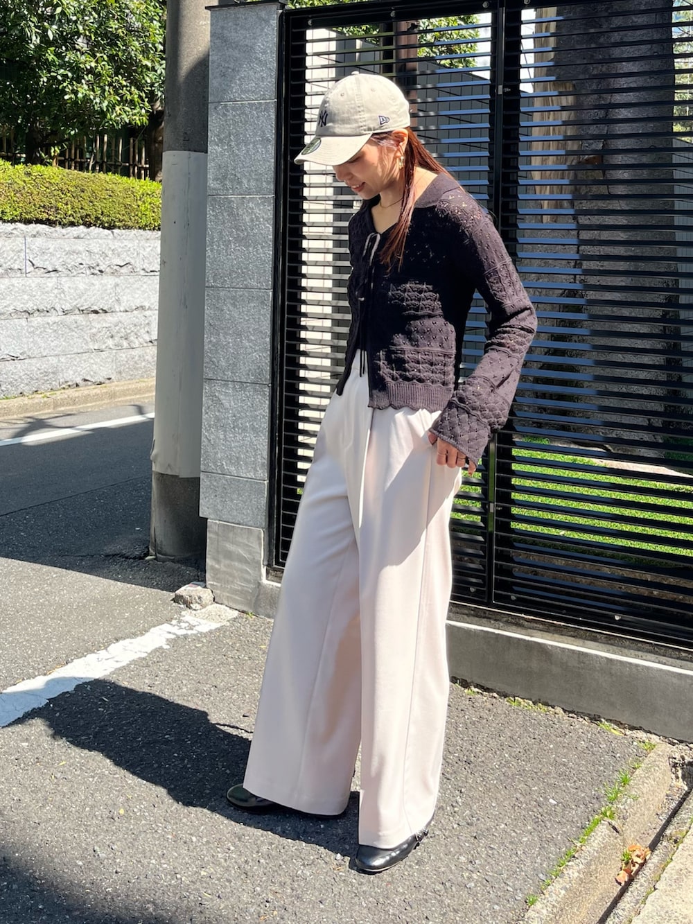 ブラック系のニット/セーター、ベージュ系のスラックス、ブラック系のパンプスを着用したレディースの春コーディネートの3枚目の写真