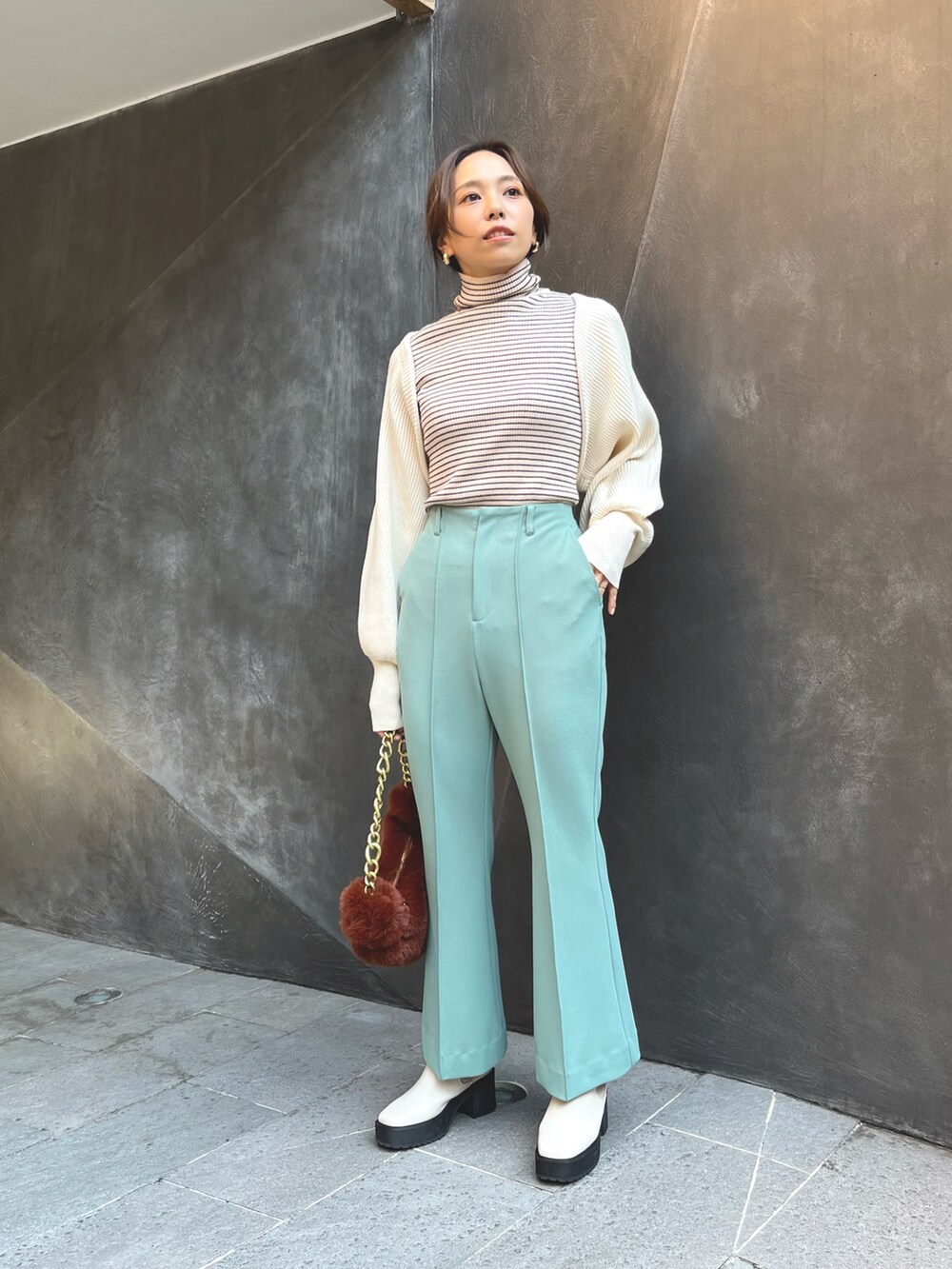 ブラウン系のハンドバッグ、ホワイト系のカーディガン/ボレロ、ホワイト系のニット/セーターを着用したレディースの秋コーディネートの3枚目の写真