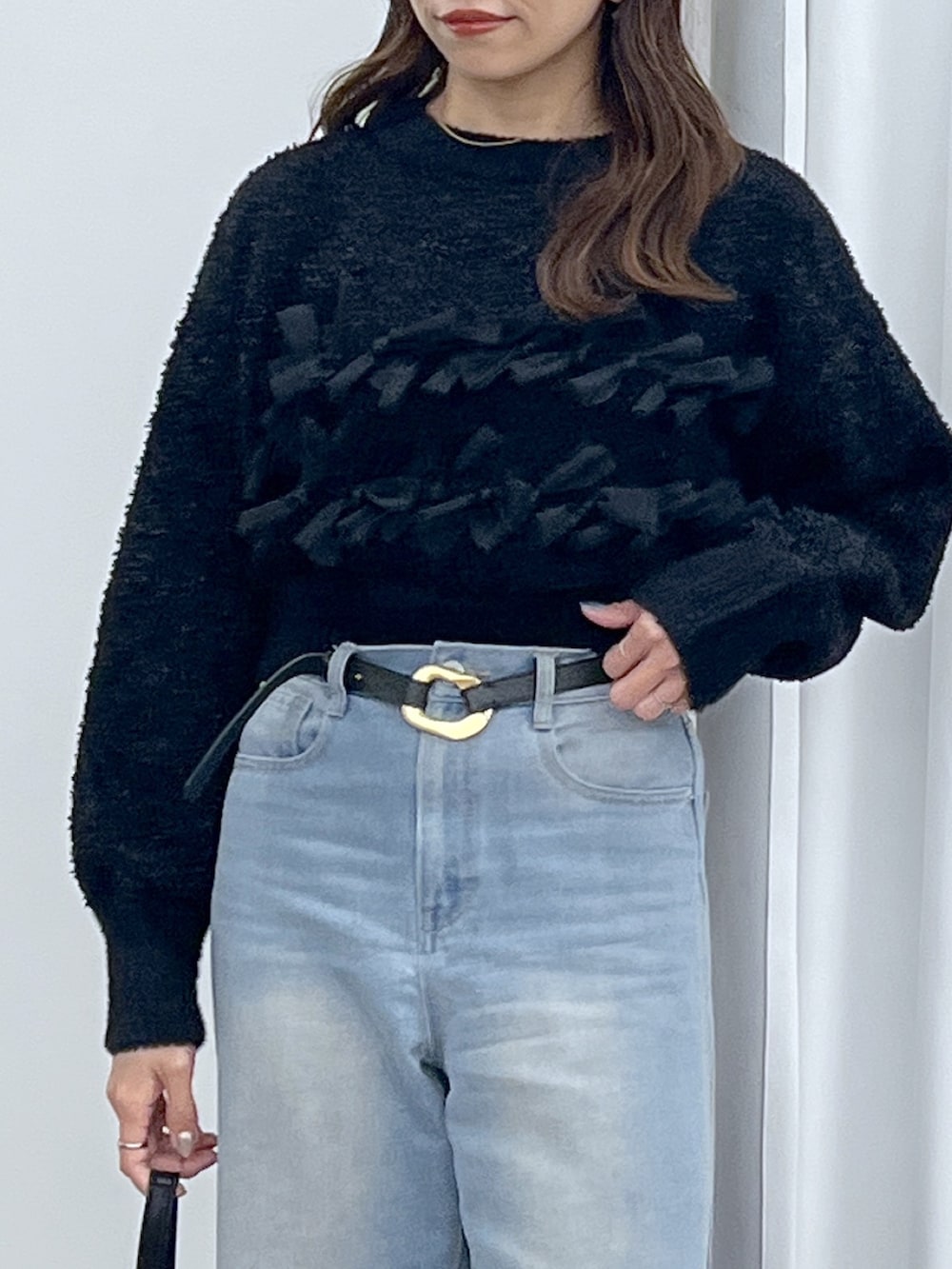 ブラック系のショルダーバッグ、ブルー系のデニムパンツ、ブラック系のニット/セーターを着用したレディースの冬コーディネートの9枚目の写真