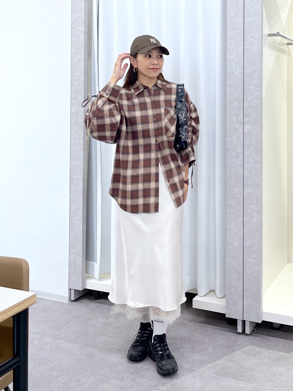 ホワイト系のスカート、ブラウン系のシャツ/ブラウス、ブラック系のショルダーバッグを着用したレディースの夏コーディネートの9枚目の写真