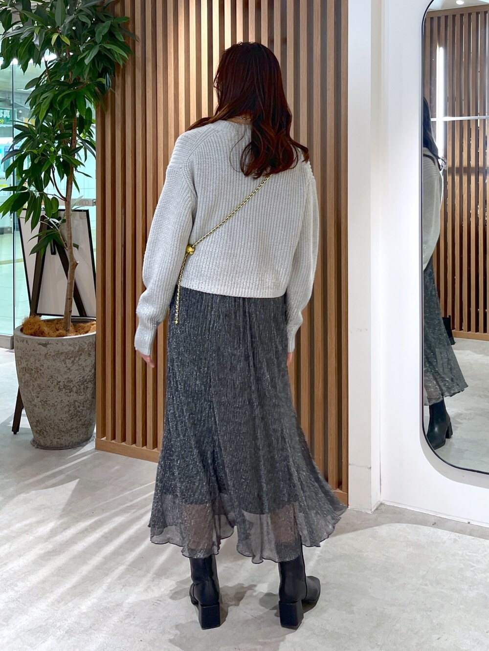 グレー系のニット/セーター、ブルー系のショルダーバッグ、ブラック系のスカートを着用したレディースの冬コーディネートの8枚目の写真