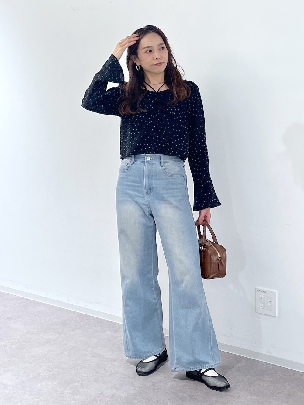 ブラック系のシャツ/ブラウス、ブラウン系のハンドバッグ、ブラック系のパンプスを着用したレディースの冬コーディネートの2枚目の写真