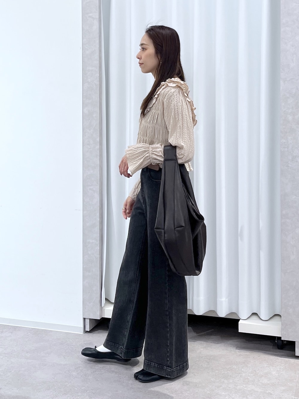 ベージュ系のシャツ/ブラウス、ブラウン系のトートバッグ、ブラック系のデニムパンツを着用したレディースの冬コーディネートの4枚目の写真