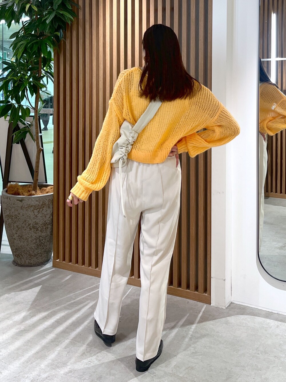 ホワイト系のショルダーバッグ、オレンジ系のニット/セーター、ホワイト系のその他パンツを着用したレディースの冬コーディネートの6枚目の写真