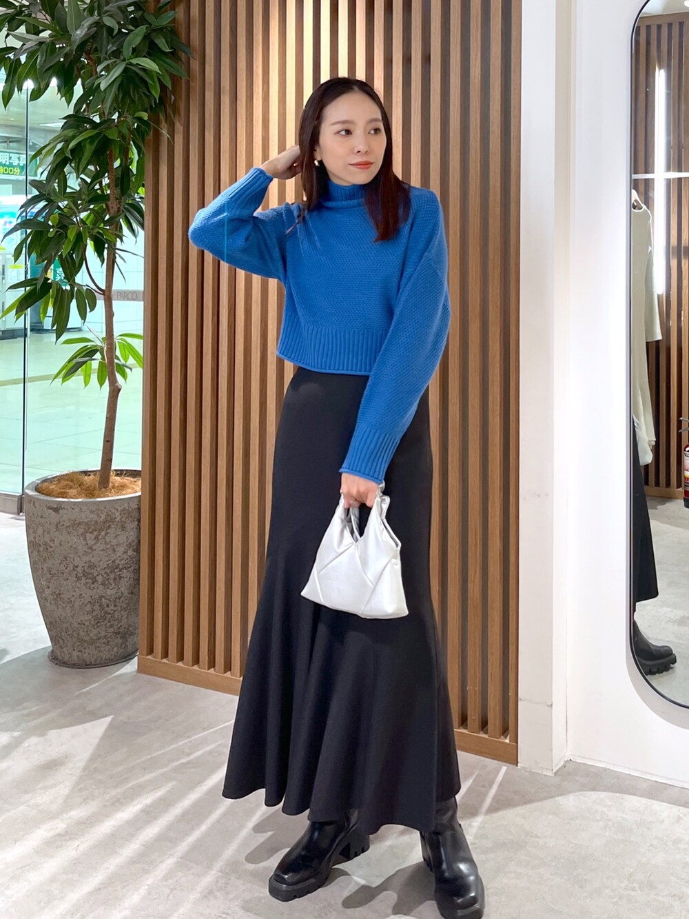 シルバー系のショルダーバッグ、ブラック系のスカート、ブルー系のニット/セーターを着用したレディースの秋コーディネートの5枚目の写真