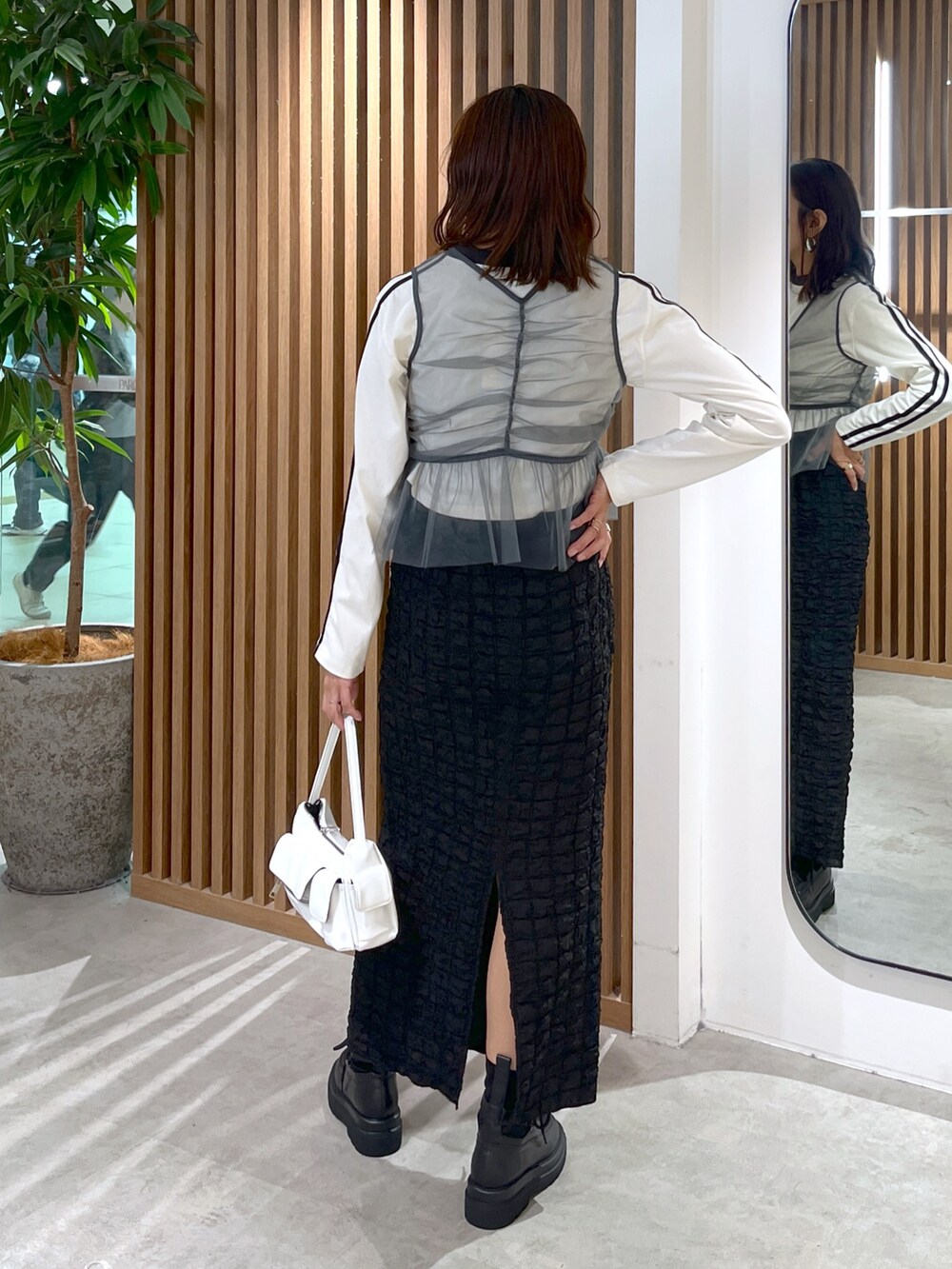 ホワイト系のTシャツ/カットソー、グレー系のシャツ/ブラウス、ブラック系のスカートを着用したレディースの秋コーディネートの5枚目の写真