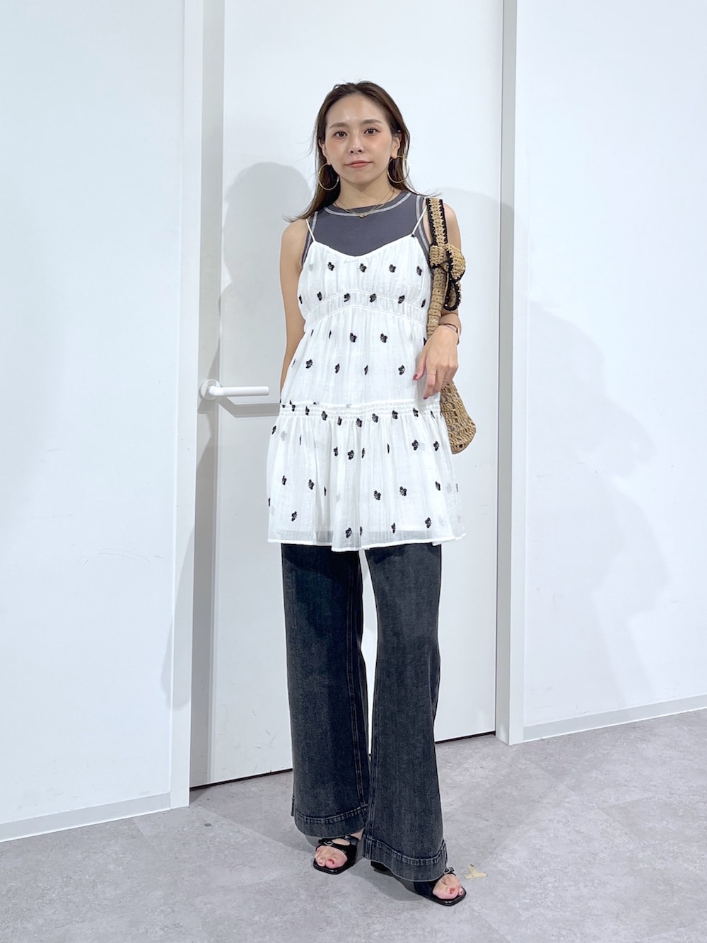 ブラック系のTシャツ/カットソー、ホワイト系のワンピース、ブラック系のデニムパンツを着用したレディースの夏コーディネートの2枚目の写真