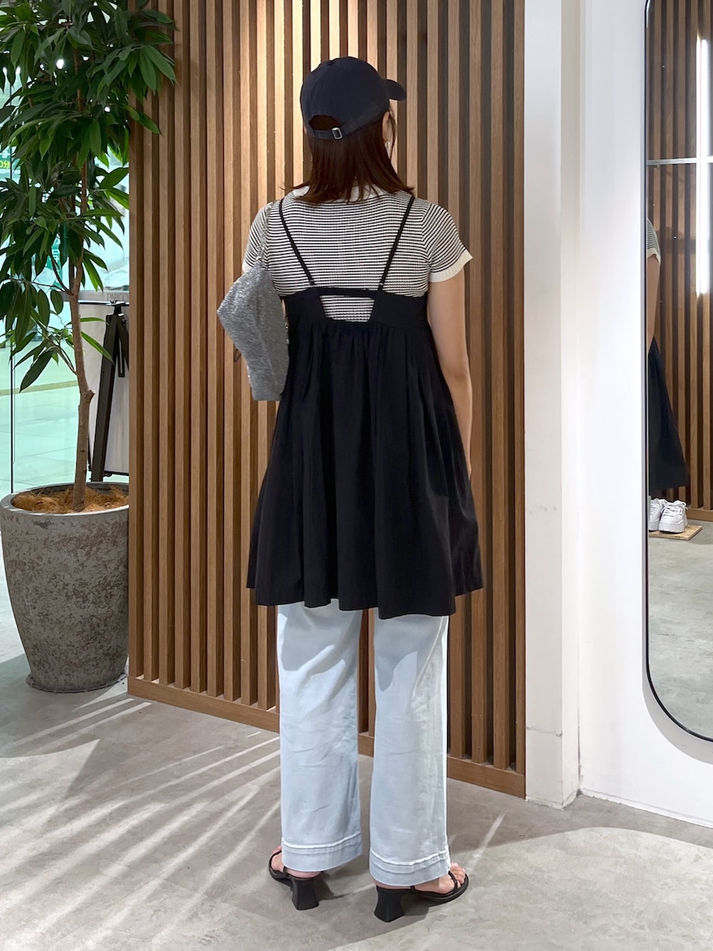 ブラック系のサンダル、ブルー系のデニムパンツ、ブラック系のワンピースを着用したレディースの夏コーディネートの7枚目の写真