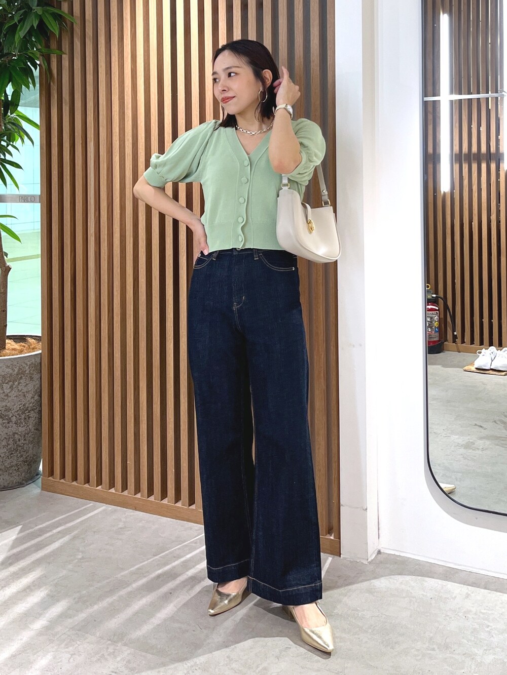 グリーン系のカーディガン/ボレロ、グレー系のショルダーバッグ、ブルー系のデニムパンツを着用したレディースの春コーディネートの7枚目の写真