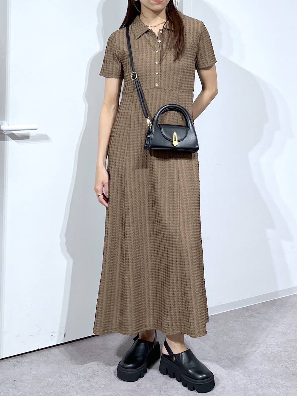 ブラック系のショルダーバッグ、ブラック系のサンダル、ブラウン系のワンピースを着用したレディースの春コーディネートの7枚目の写真