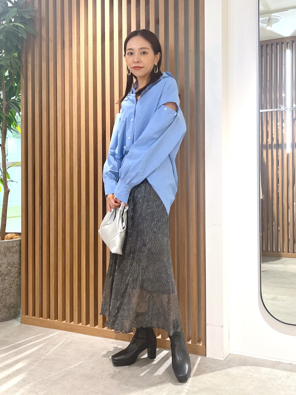 ブルー系のシャツ/ブラウス、ブラック系のスカート、シルバー系のショルダーバッグを着用したレディースの秋コーディネートの3枚目の写真