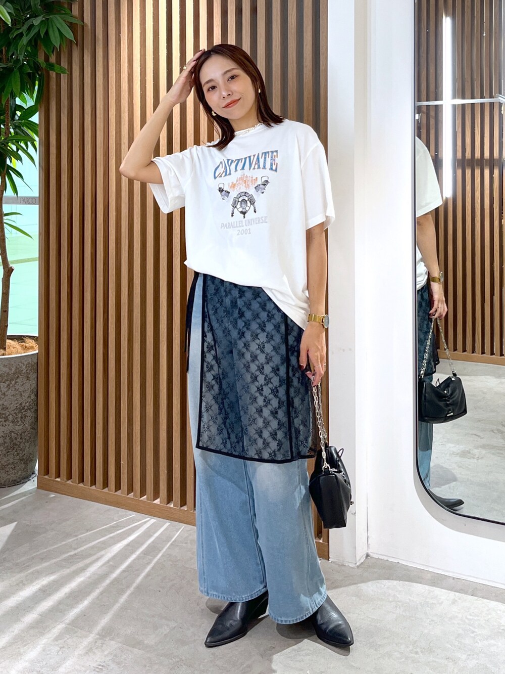 ホワイト系のTシャツ/カットソー、ブラック系のハンドバッグ、ブラック系のスカートを着用したレディースの秋コーディネートの7枚目の写真