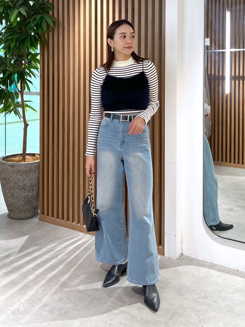 ブラック系のキャミソール、ホワイト系のニット/セーター、ブラック系のトートバッグを着用したレディースの秋コーディネートの8枚目の写真