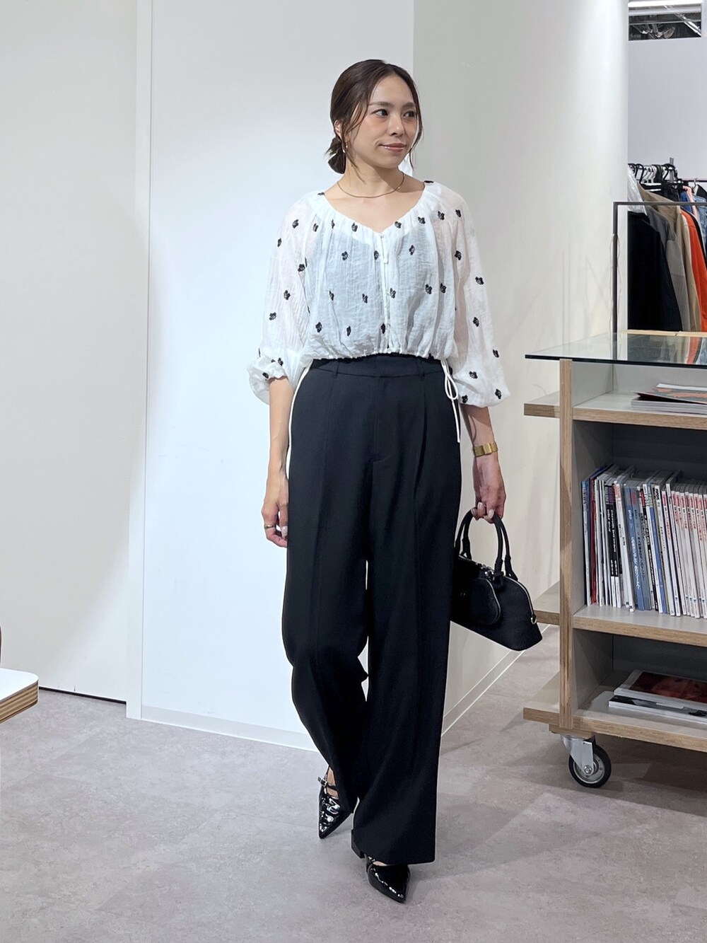 ブラック系のボストンバッグ、ブラック系のスラックス、ブラック系のパンプスを着用したレディースの夏コーディネートの10枚目の写真