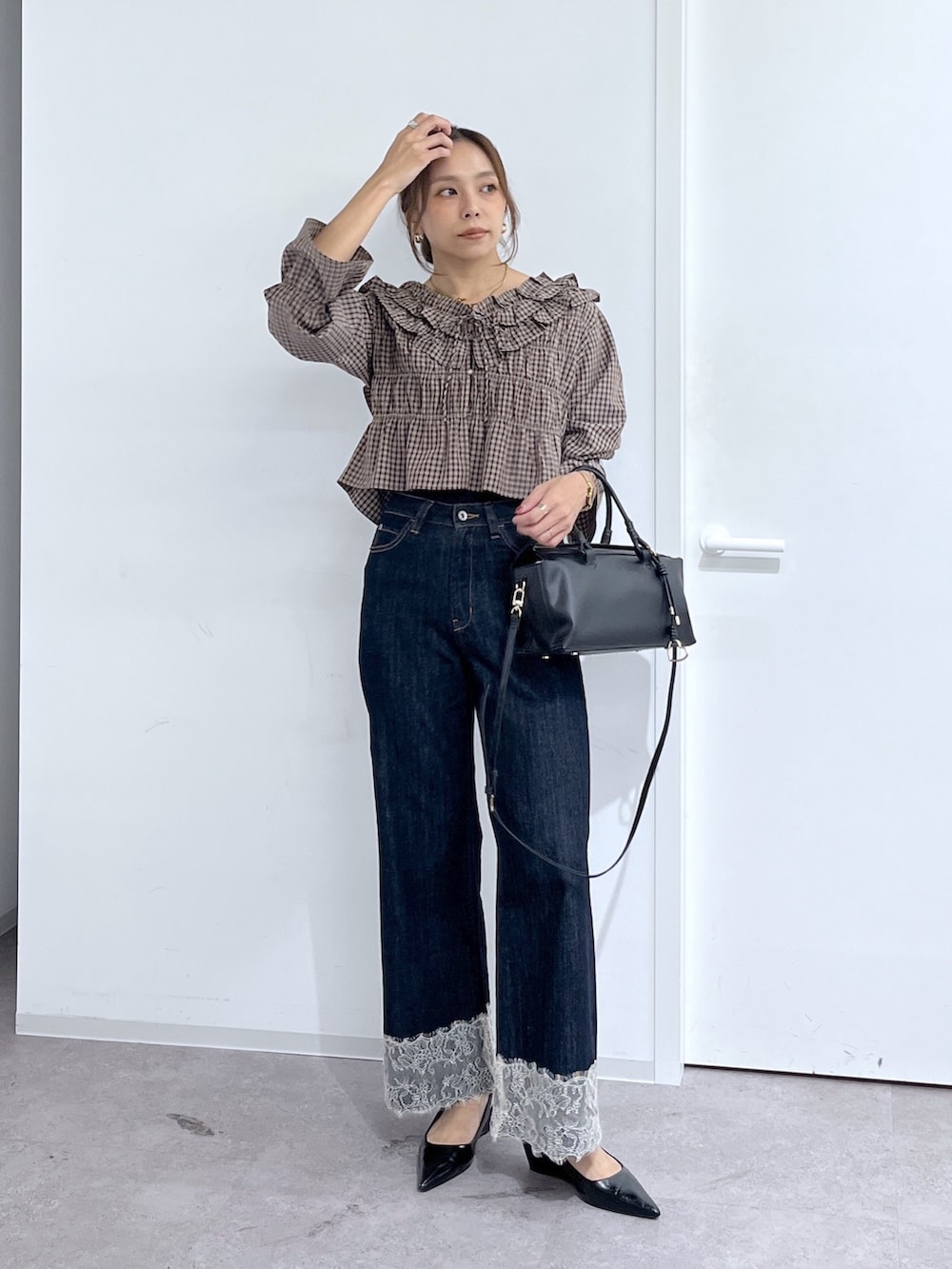 ブルー系のデニムパンツ、ブラック系のハンドバッグ、ブラウン系のシャツ/ブラウスを着用したレディースの秋コーディネートの9枚目の写真