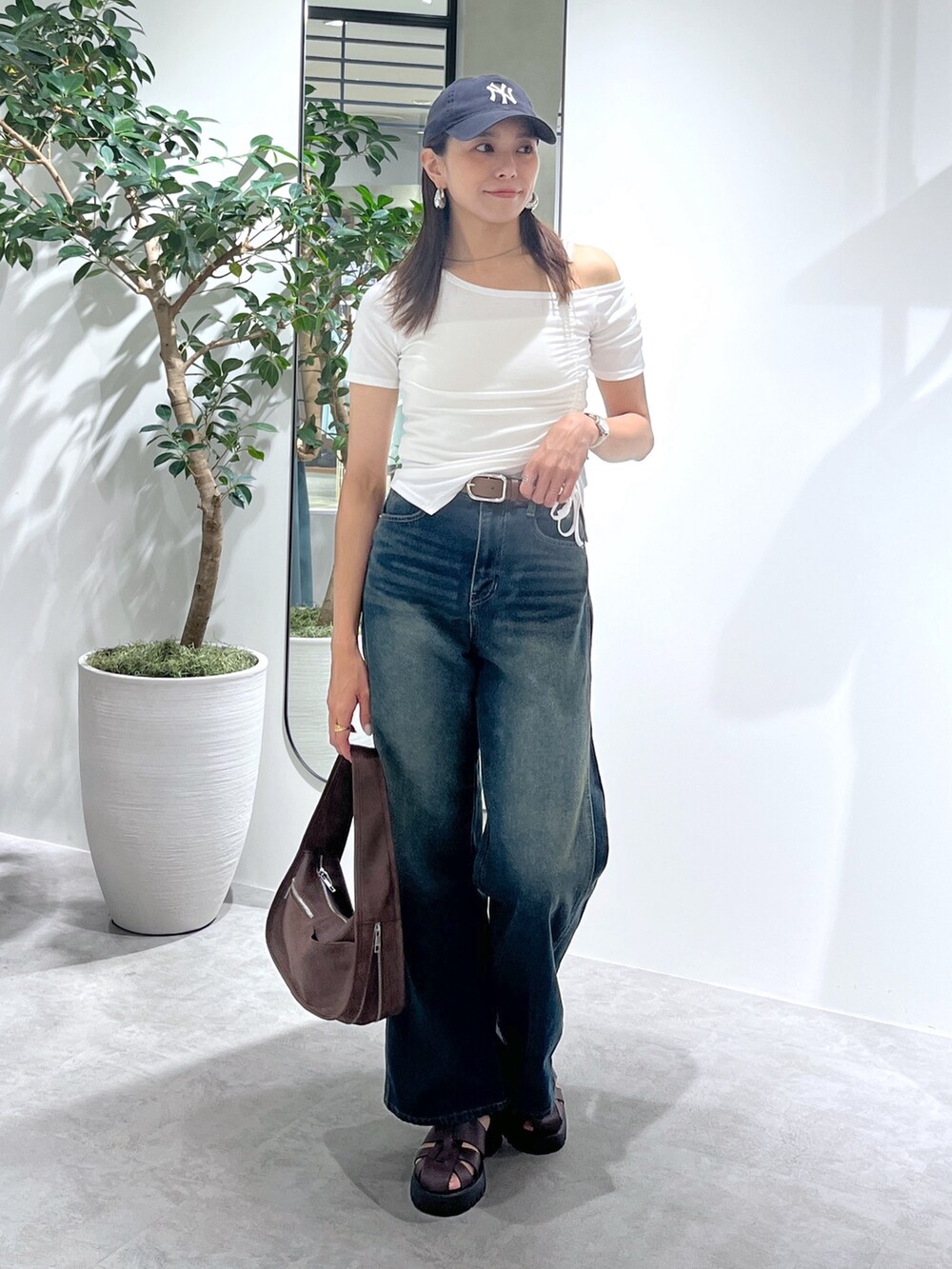 ホワイト系のTシャツ/カットソー、ホワイト系のキャミソール、ブルー系のデニムパンツを着用したレディースの夏コーディネートの2枚目の写真