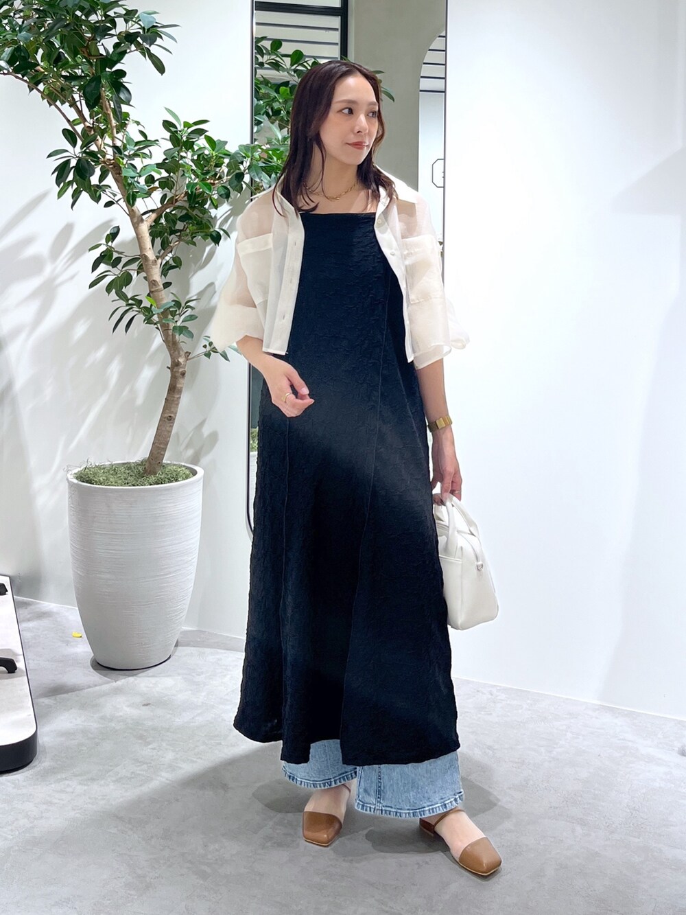 ホワイト系のシャツ/ブラウス、ブラック系のワンピース、ホワイト系のトートバッグを着用したレディースの春コーディネートの3枚目の写真