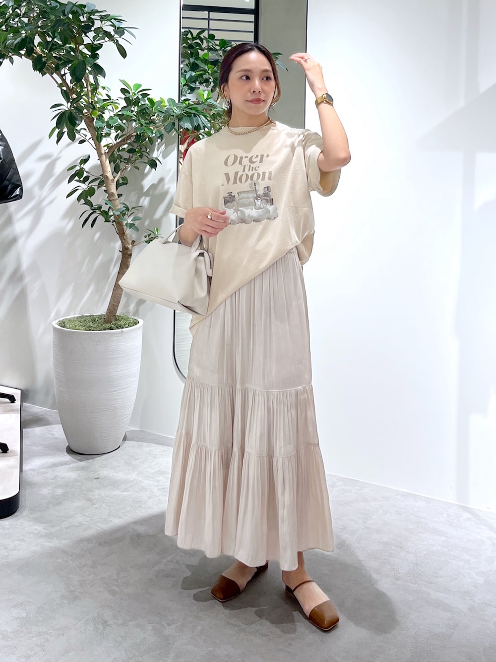 ベージュ系のTシャツ/カットソー、ホワイト系のショルダーバッグ、ホワイト系のスカートを着用したレディースの春コーディネートの3枚目の写真